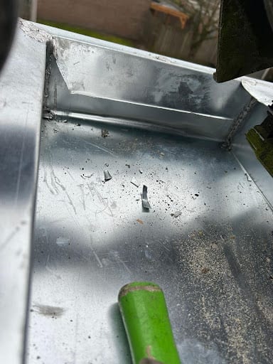 Dakdekker herstelt een zinken dakgoot