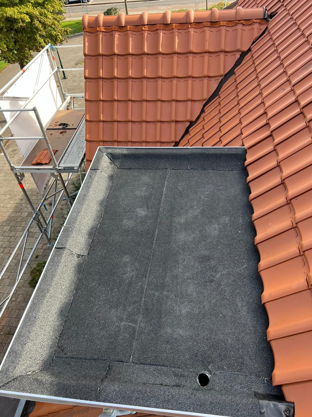 Aansluiting van bitumen dakbedekking op een plat dak tijdens onderhoud
