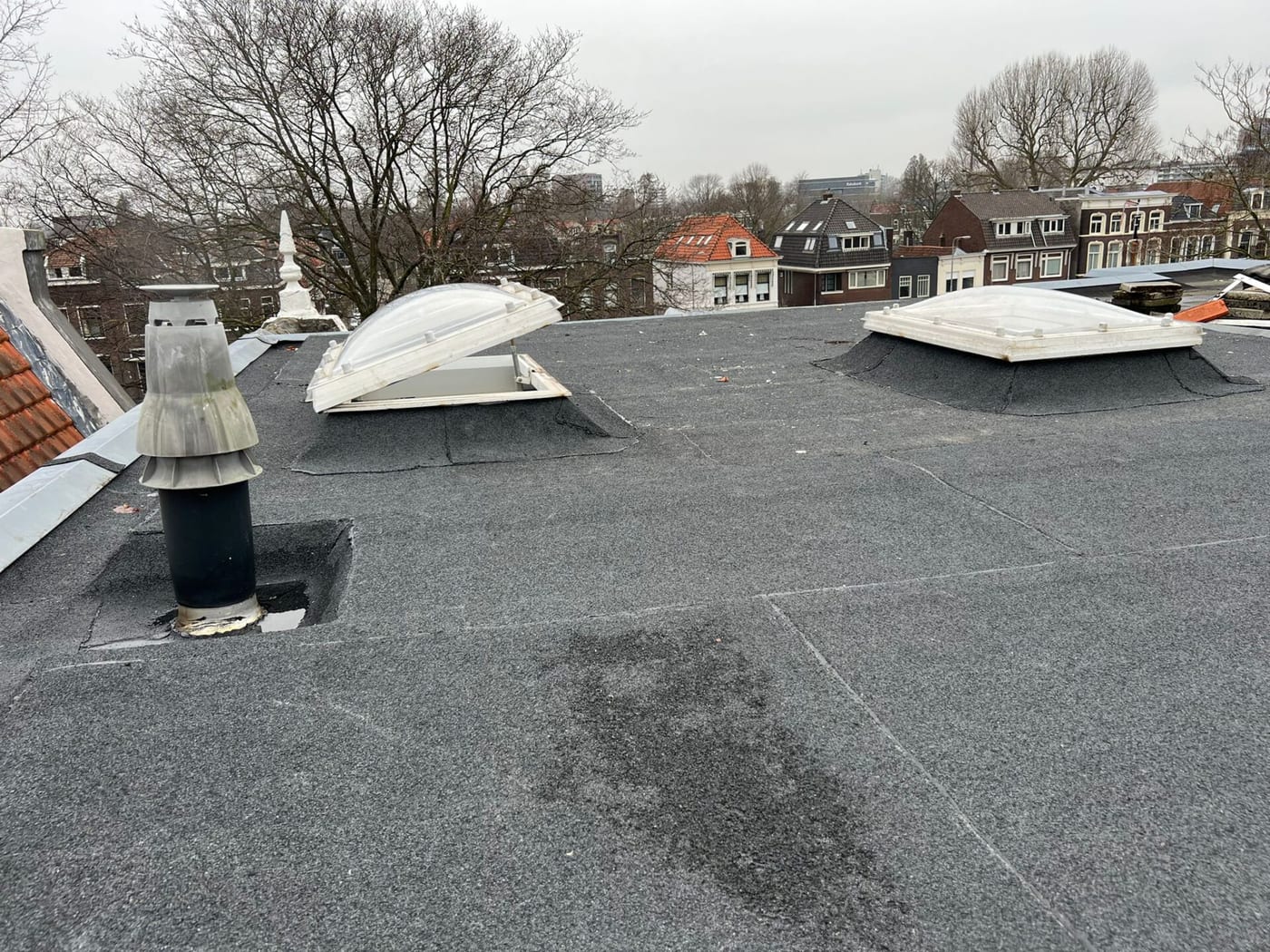 Plat dak dat wordt gerenoveerd om plasvorming te verhelpen