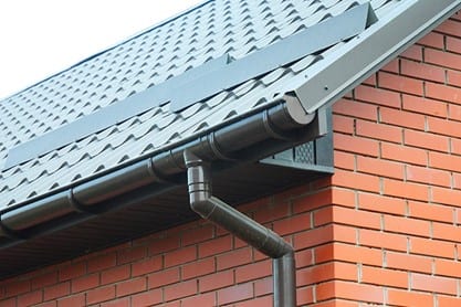 Gerepareerde dakgoot met hemelwaterafvoer aan een bakstenen woning