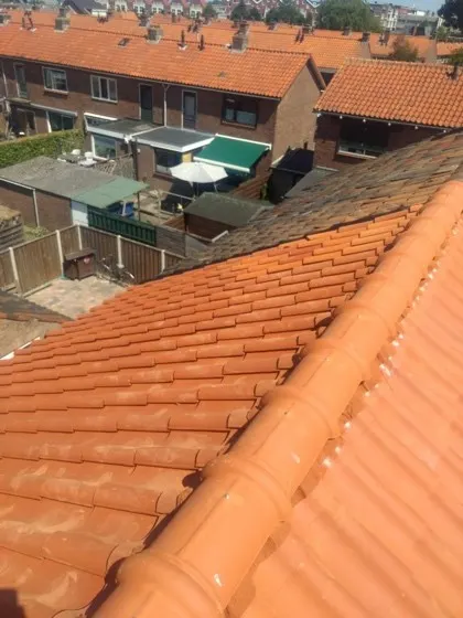 Rijwoningen met oranje pannendaken en een nieuwe nok