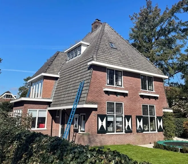 Ladder tegen een woning voor controle van de dakgoten