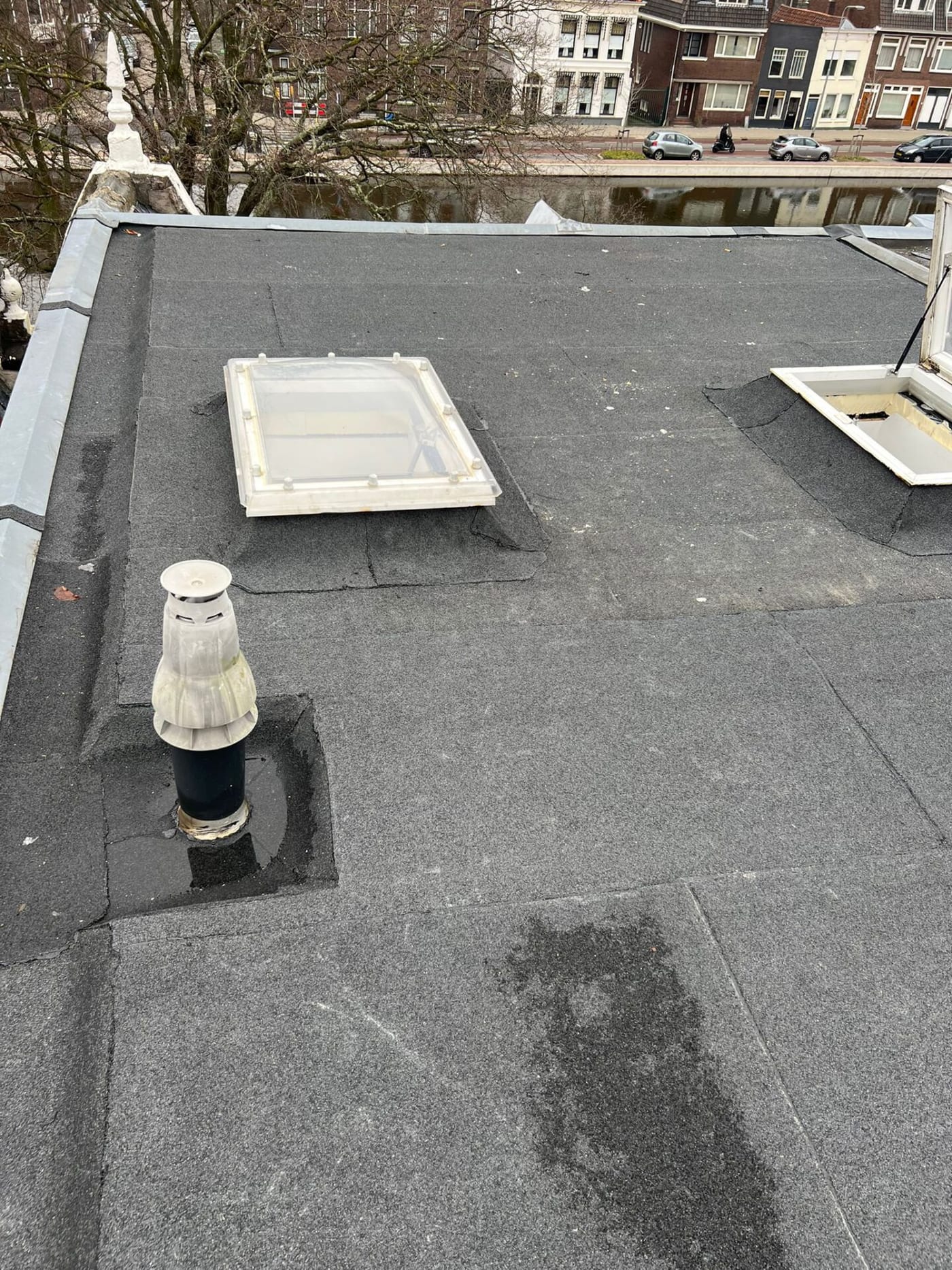 Plat dak met bitumen dakbedekking, lichtkoepel en ontluchting