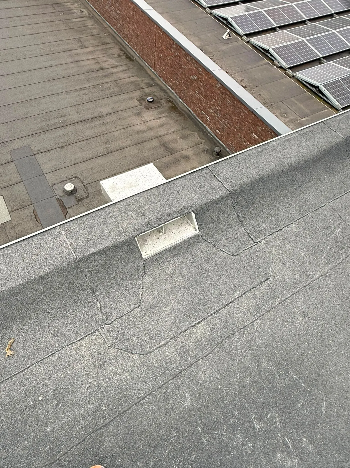 Bitumen dak met zonnepanelen op een plat dak