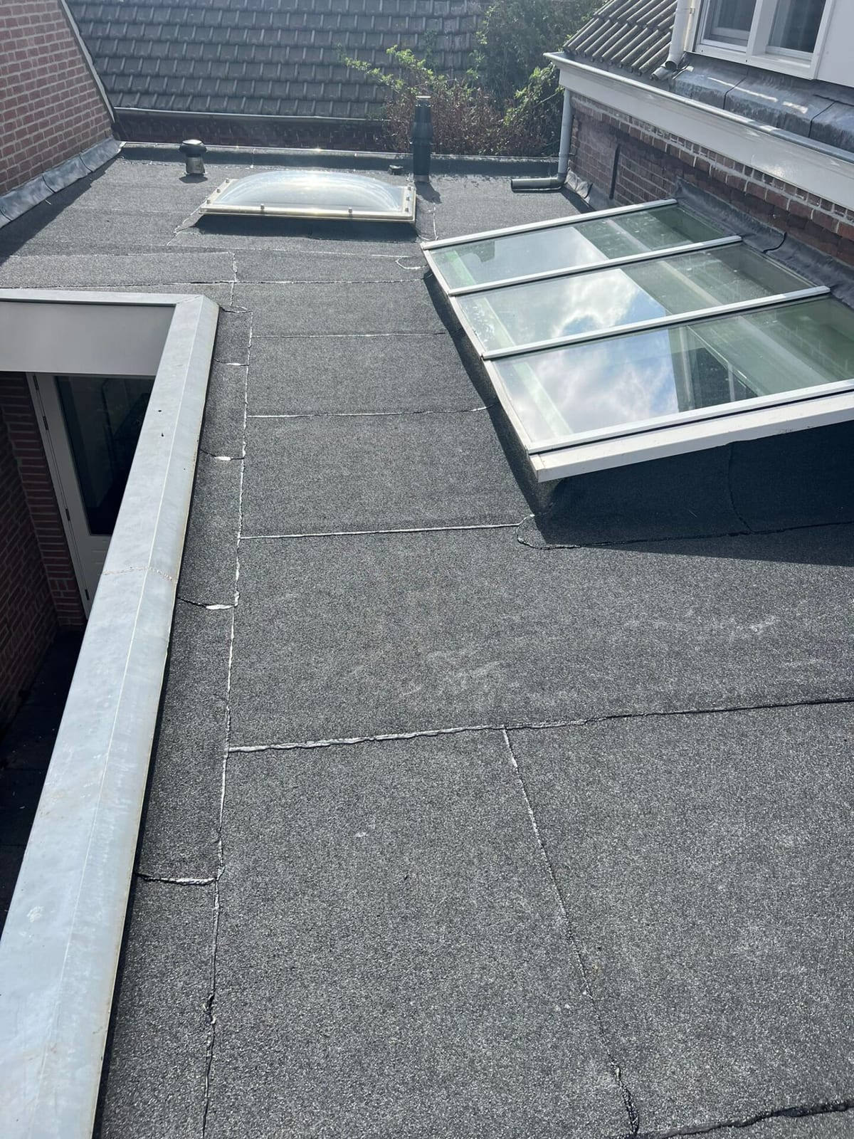 Bitumen dakrenovatie rond een lichtstraat