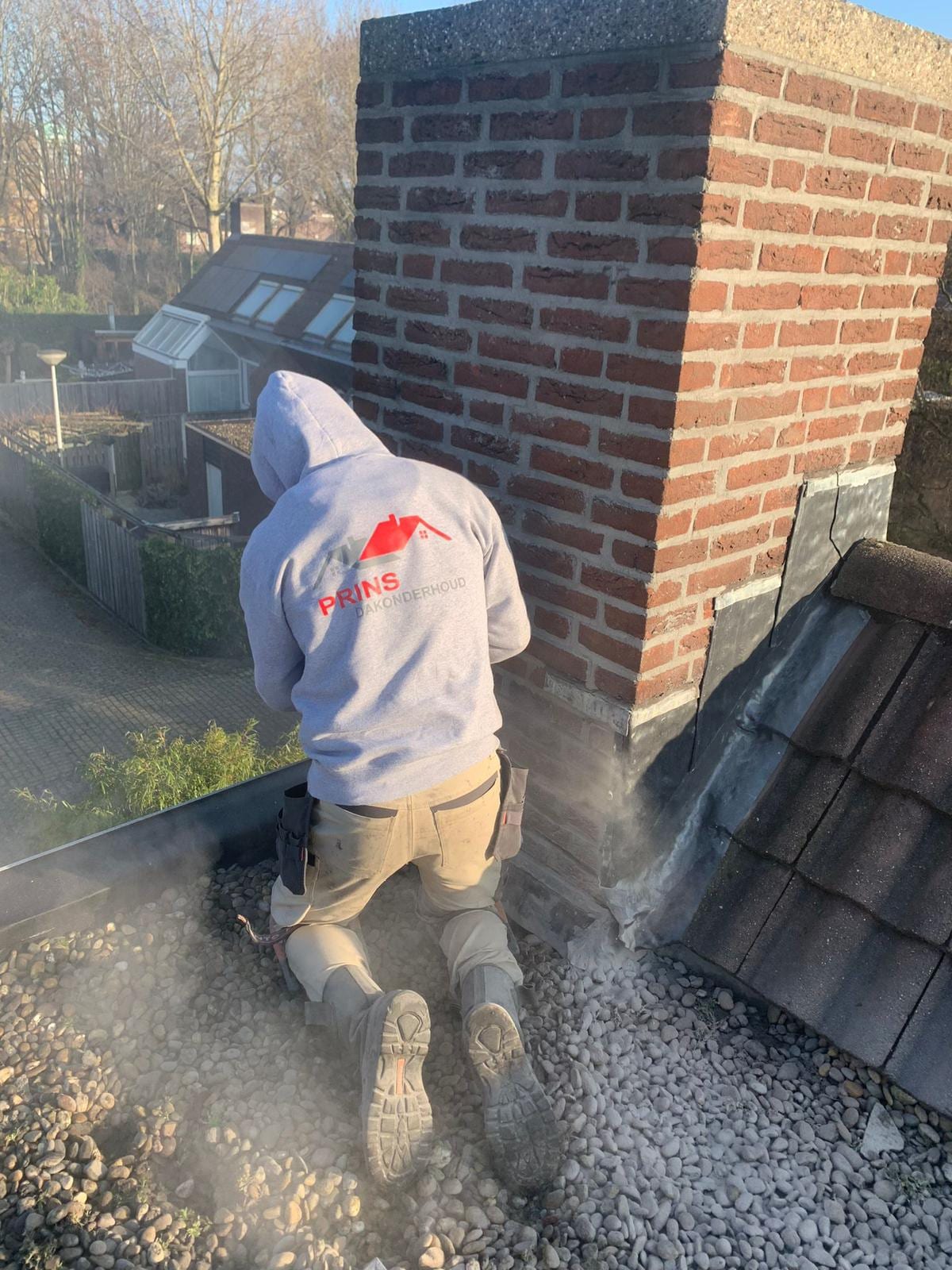 Dakdekker van Prins aan het werk bij een schoorsteen