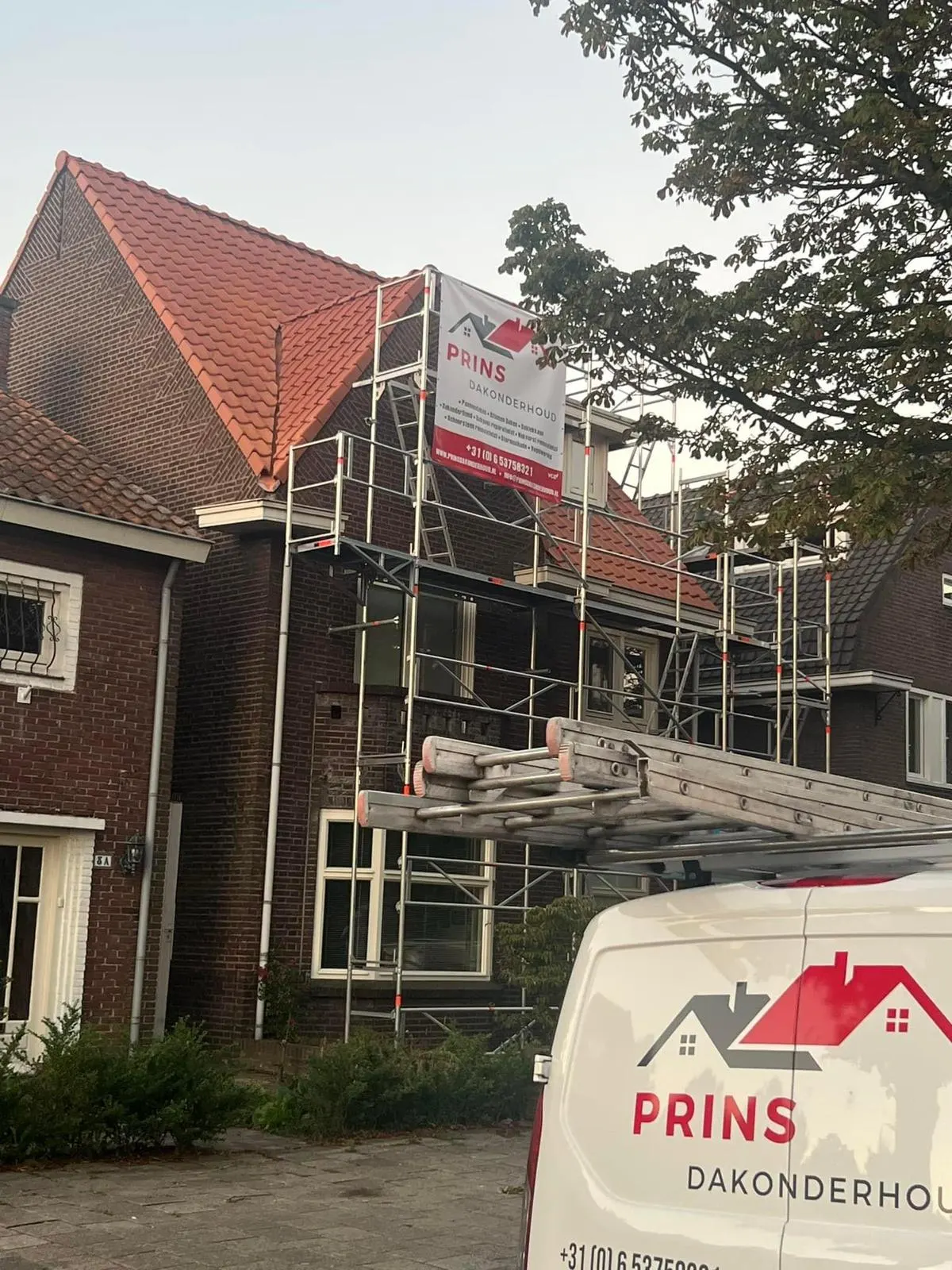 Steiger met spandoek van Prins Dakonderhoud bij een woning