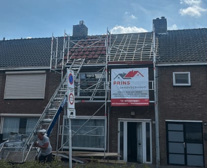 Steiger met spandoek bij een rij woningen tijdens dakwerk